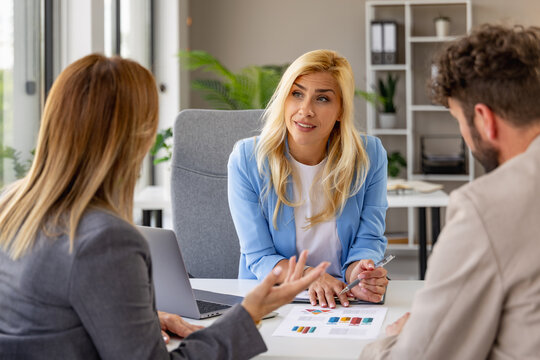 Business consultation with female advisor meeting clients in a modern office to review financial charts
