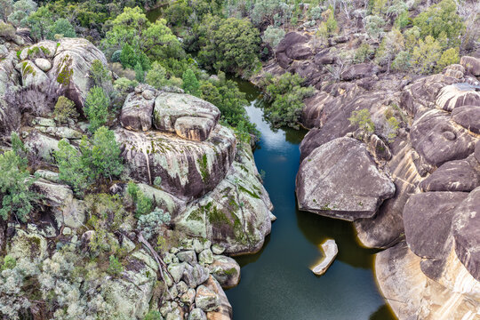 Aerial view of the natural rock pool and striking granite rock formations at Cranky Rock Nature Reserve near Warialda, NSW. Carved by Reedy Creek and surrounded by native bushland