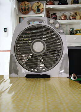 Ventilador de aspas y h&eacute;lices corriente de aire dom&eacute;stico calima, golpe de calor y aviso naranja alerta roja electrodom&eacute;stico propeller blade fan en mesa calor verano ola de calor calima