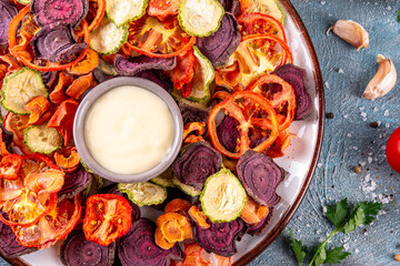 Healthy alternative for traditional potato chips, snack air fried vegetables chips, raw organic dehydrated veggie chips, beets, carrots, zucchini, kale, tomatoes, with white sauce dip © ricka_kinamoto