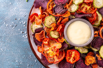 Healthy alternative for traditional potato chips, snack air fried vegetables chips, raw organic dehydrated veggie chips, beets, carrots, zucchini, kale, tomatoes, with white sauce dip © ricka_kinamoto