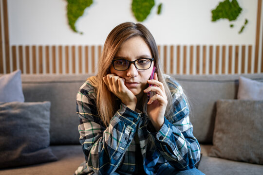 Close anxiety worried sad serious frustrated upset Caucasian woman lady girl indoor at home female talking mobile phone smartphone conversation listening bad news cellphone call problem trouble stress
