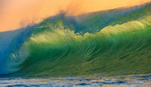 Powerful Ocean Wave Curling with Translucent Green Water at Golden Sunset