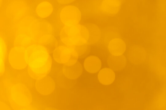 Abstract warm golden bokeh lights background with soft yellow glow
