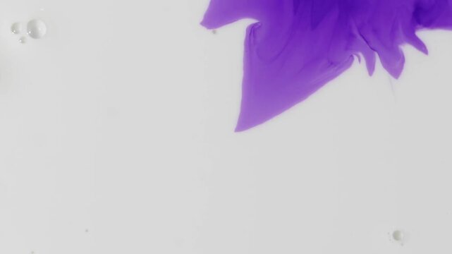 The process of diffusion of dark blue (violet) ink as it spreads slowly over the surface of wet textured paper. 