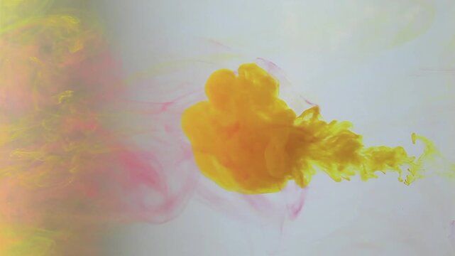 the beauty of fluid dynamics in action. Deep yellow ink is slowly injected into the water, creating thick, cloud- or smoke-like plumes that swirl gracefully. 