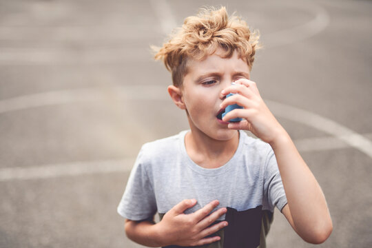 Boy with inhaler having breath problem
