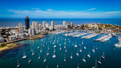 Panoramic drone view of Punta del Este skyline, marina and anchored sailboats along the Atlantic coast on a sunny summer day in Uruguay. © Francois Quartiers