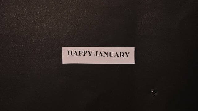 Happy January New Year Greeting Card Placed by Hand on Dark Minimal Background