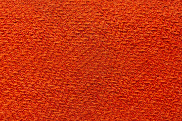 Naklejka premium Orange knitted textile texture with abstract pattern