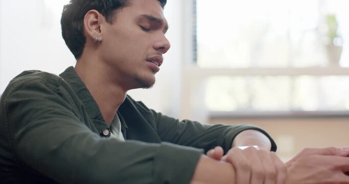 African man in green shirt reacting to smartwatch alert, checking watch then reading phone at home