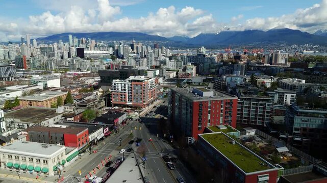 City Neighbourhood And Traffic Along The Main Street And Broadway Near The New Skytrain Station In BC, Canada. Aerial Shot