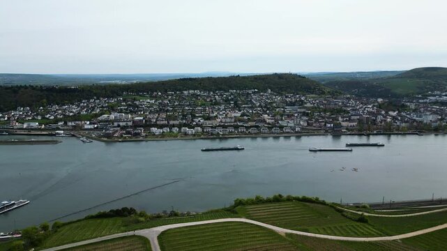 Aerial tracking shot of cargo ships on the Rhine River, Rudesheim, Germany