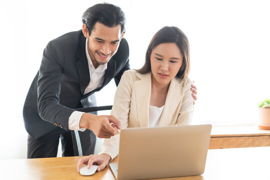 Disgusted asian young employee, pressure business woman uncomfortable, looking hand of boss or colleague  male when touching her shoulder, embrace. Sexual harassment inappropriate at office work.