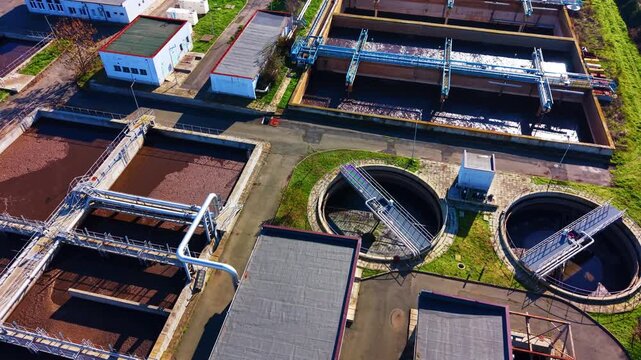 Rectangular filtration basins at a treatment site. Drone shot of aeration channels, bridge walkways and reddish sludge water.
