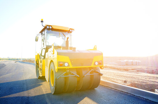 Road roller on asphalt road construction. Vibrator compactor machine on roadworks, asphalt pavement. Asphalt paving installation. Vibration roller on highway asphalting. Road compaction equipment. 
