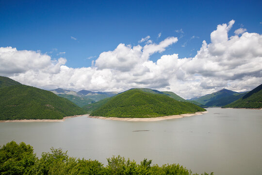 River reservoir with green hills and blue sky
