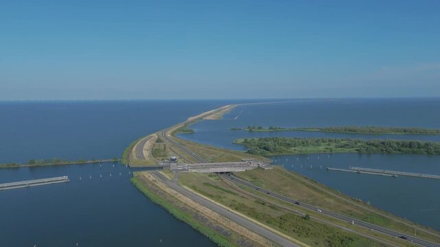 Aerial drone footage of Naviduct Krabbersgat and the long dike connecting Enkhuizen and Lelystad in the Netherlands. Dutch water management infrastructure with road traffic, navigation channel, locks.