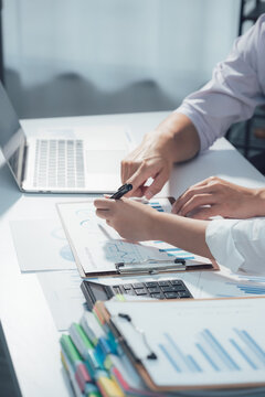  A diverse business team collaborates over financial data and charts in a modern office setting, reflecting the focused energy and shared ambition of a high-performing team.