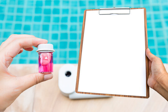 Water sample tube in girl hand with blank report paper on wooden clipboard over blurred Quality water analysis tool on swimming pool edge, measure chlorine and pH, pH testing with water photometer