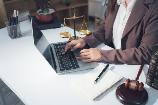 Legal Consultation: A close-up view capturing the atmosphere of legal consultation. A laptop, scales, and documents are arranged on the table, creating a professional environment