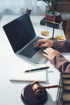 Legal Consultation: A close-up view capturing the atmosphere of legal consultation. A laptop, scales, and documents are arranged on the table, creating a professional environment