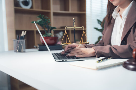 Legal Consultation: A close-up view capturing the atmosphere of legal consultation. A laptop, scales, and documents are arranged on the table, creating a professional environment