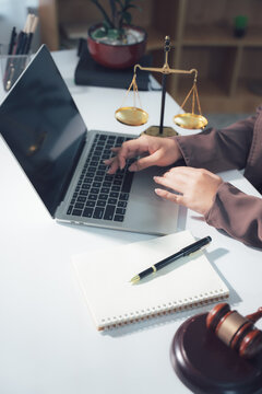 Legal Consultation: A close-up view capturing the atmosphere of legal consultation. A laptop, scales, and documents are arranged on the table, creating a professional environment