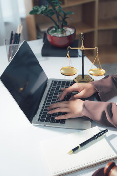 Legal Consultation: A close-up view capturing the atmosphere of legal consultation. A laptop, scales, and documents are arranged on the table, creating a professional environment