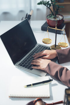 Legal Consultation: A close-up view capturing the atmosphere of legal consultation. A laptop, scales, and documents are arranged on the table, creating a professional environment