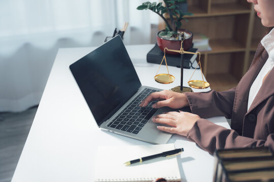 Legal Consultation: A close-up view capturing the atmosphere of legal consultation. A laptop, scales, and documents are arranged on the table, creating a professional environment