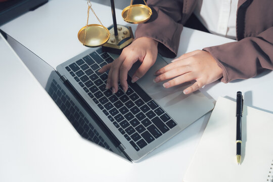 Legal Consultation: A close-up view capturing the atmosphere of legal consultation. A laptop, scales, and documents are arranged on the table, creating a professional environment