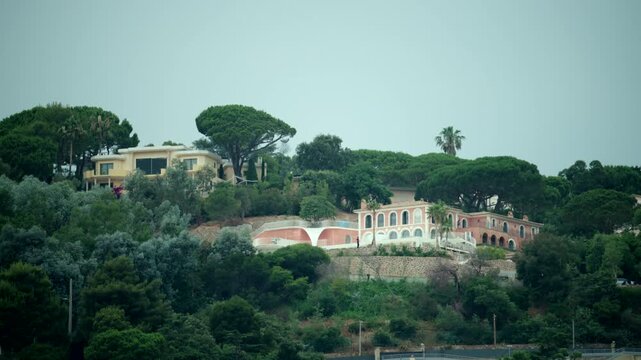 Palais bulles, bubble palace, and other luxurious residences nestled among dense green trees on a hillside in Theoule-sur-Mer, french riviera