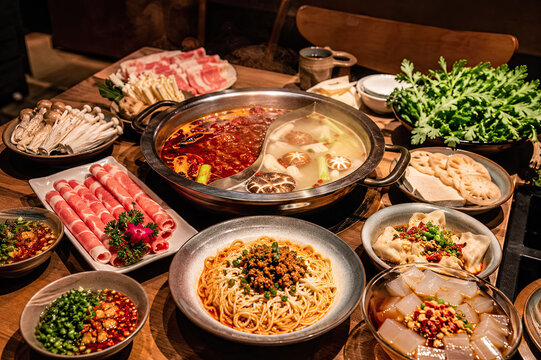 Overhead Chinese hot pot feast with sliced meat noodles and fresh greens.generative AI