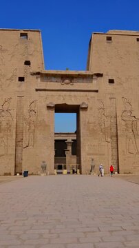Massive pylon facade of Edfu Temple with giant pharaoh reliefs and central gateway, Egypt. Best preserved ancient Egyptian temple exterior for travel and history projects