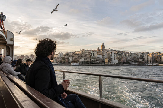 Passenger watching Istanbul waterfront from the rail of a moving ferry.generative AI