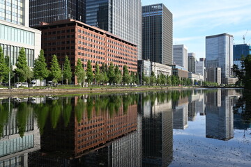 皇居外苑の水辺に映る高層ビル群と並木が描く都会の風景   Urban skyline reflected on the waters of Kōkyo Gaien with tree-lined paths  © 拓也 山並