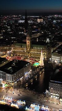 Aerial footage of Hamburg at night during advent season with historic Rathaus and traditional Christmas market.