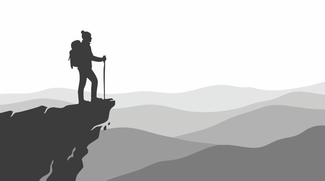 Silhouette of a hiker standing on a cliff with mountain backdrop