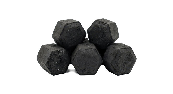 A close-up shot of five dark gray hexagonal charcoal briquettes stacked together on a white background.