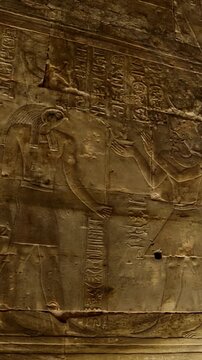 Hieroglyphs and images of Egyptian gods at the Ancient Egyptian Temple of Edfu. Edfu is the site of a Ptolemaic-era Temple of Horus and an ancient settlement in Egypt