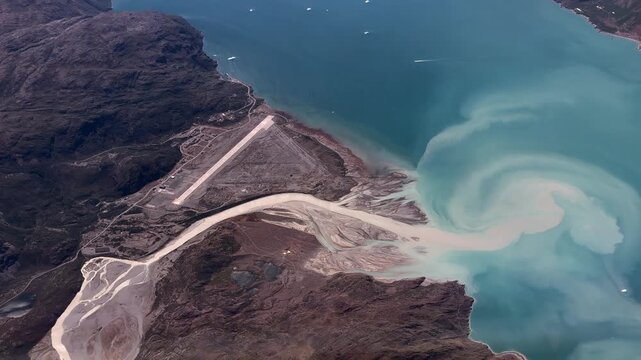 flying along Narsarsuaq Airport (IATA: UAK, ICAO: BGBW) Greenland, located next to Tunulliarfik Fjord  in the Kujalleq municipality in southern Greenland with mountain landscape - 4k aerial video