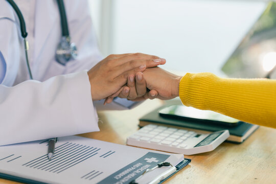 Professional woman physician talking and giving advice to female patient at clinic desk