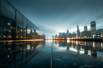 Fototapeta premium A moody, low-light cityscape reflection on a wet street under an overcast sky.