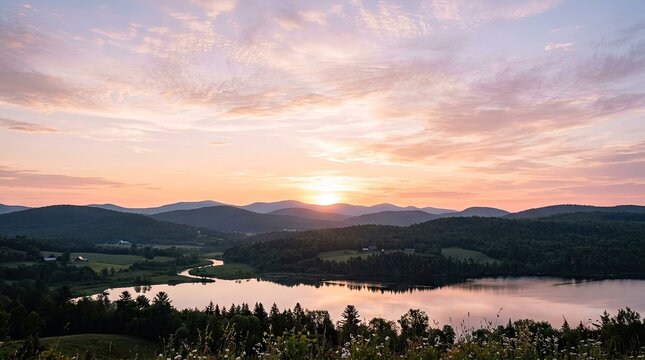 A picturesque sunset over a serene lake with rolling hills in the background, illuminated by a warm, golden glow, with a few scattered clouds in the sky.