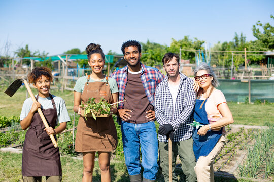 Diverse group of friends gardening in a community patch