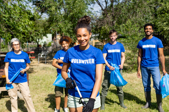 Diverse volunteers smiling after community cleanup event