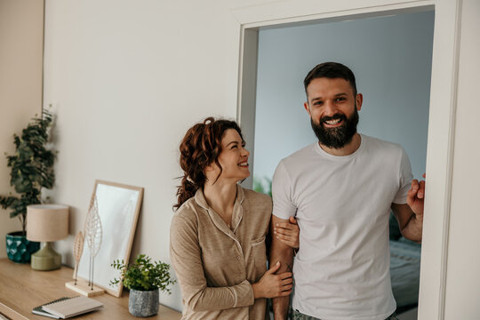 Happy couple standing in doorway smiling
