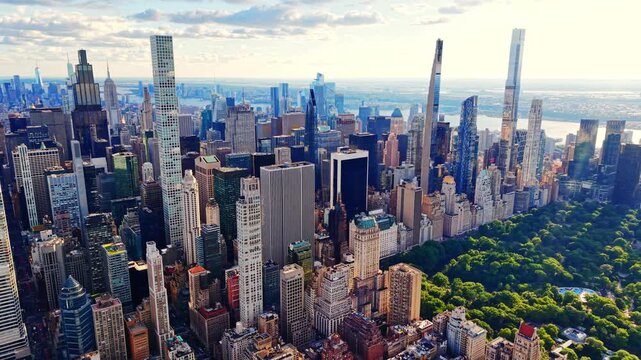 Elevated view of a slim glass skyscraper, New York. Turquoise windowed tower rises above the Midtown skyline with the East River in the distance.