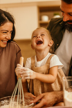 Family enjoying cooking together in kitchen laughing